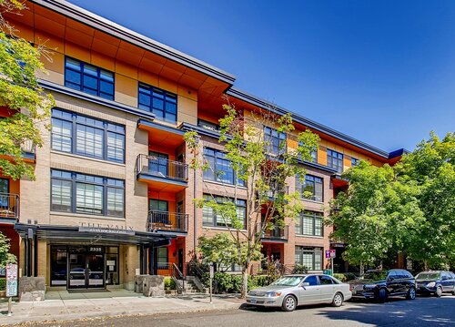 Brick and wood-clad apartment building on a tree-lined street