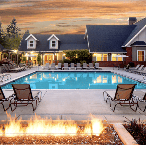 Resort-style apartment pool and fire feature at sunset