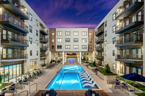Apartment courtyard pool framed by balconies at twilight