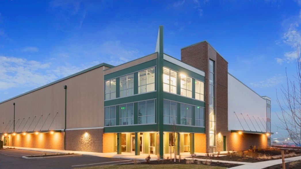 Self-storage facility in Bend, Oregon, with a green-framed glass entry lit at dusk