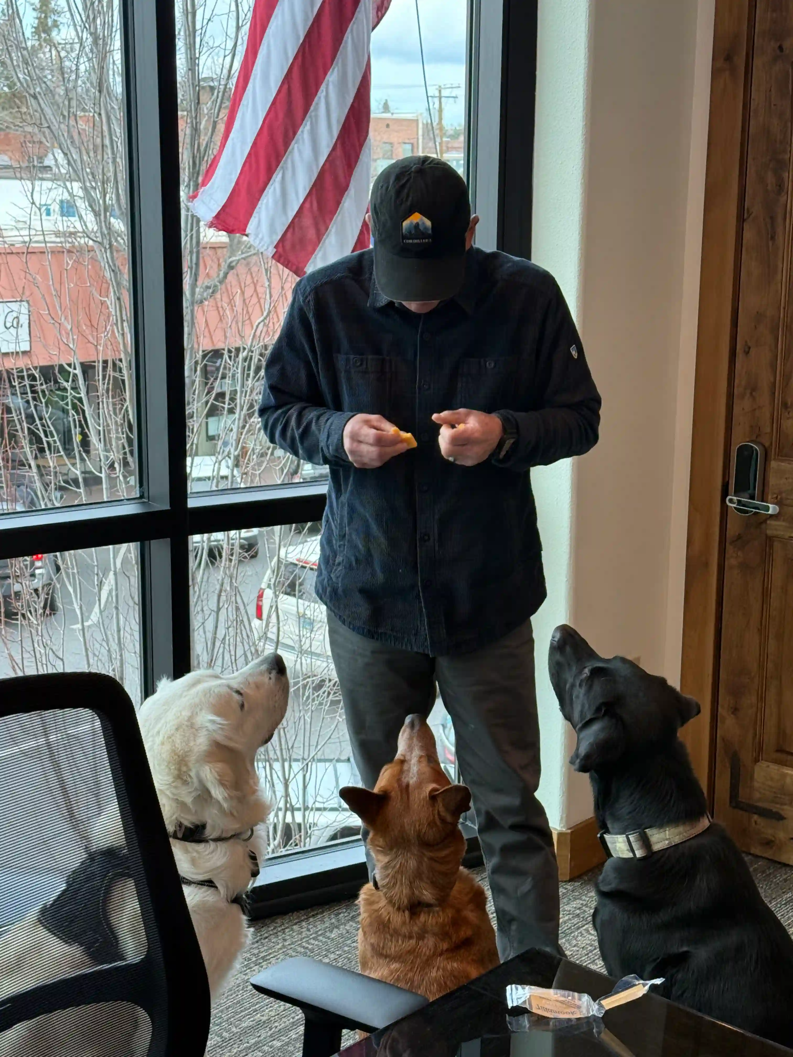 Ruger, Dale, and Finn gathered around a team member in the Cordillera office